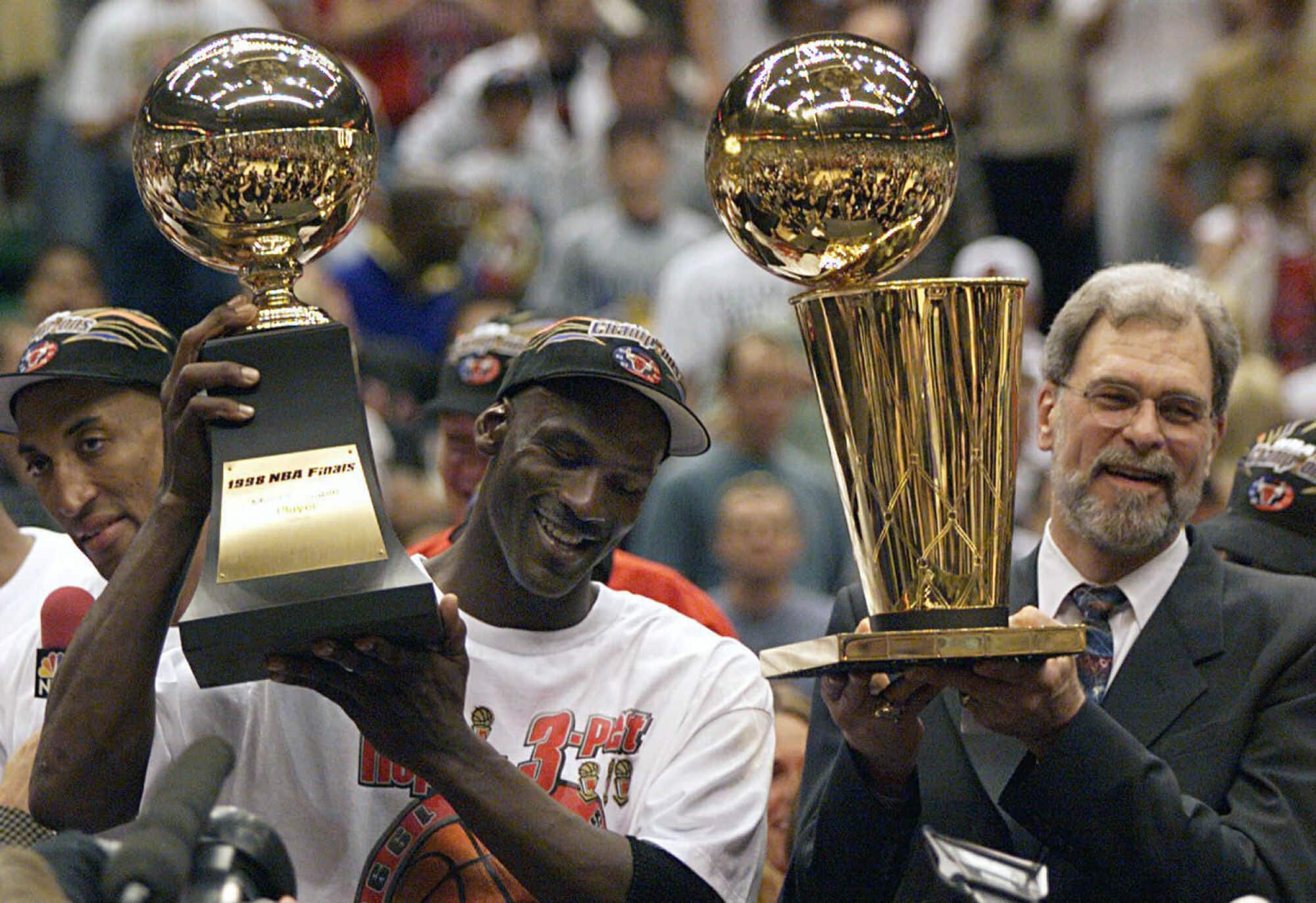 Michael Jordan com o trof&eacute;u de MVP e o t&eacute;cnico Phil Jackson com o trof&eacute;u do campeonato depois que os Bulls venceram o Utah Jazz e conquistaram seu sexto t&iacute;tulo da NBA. Cr&eacute;dito: SUSA/Icon Sport