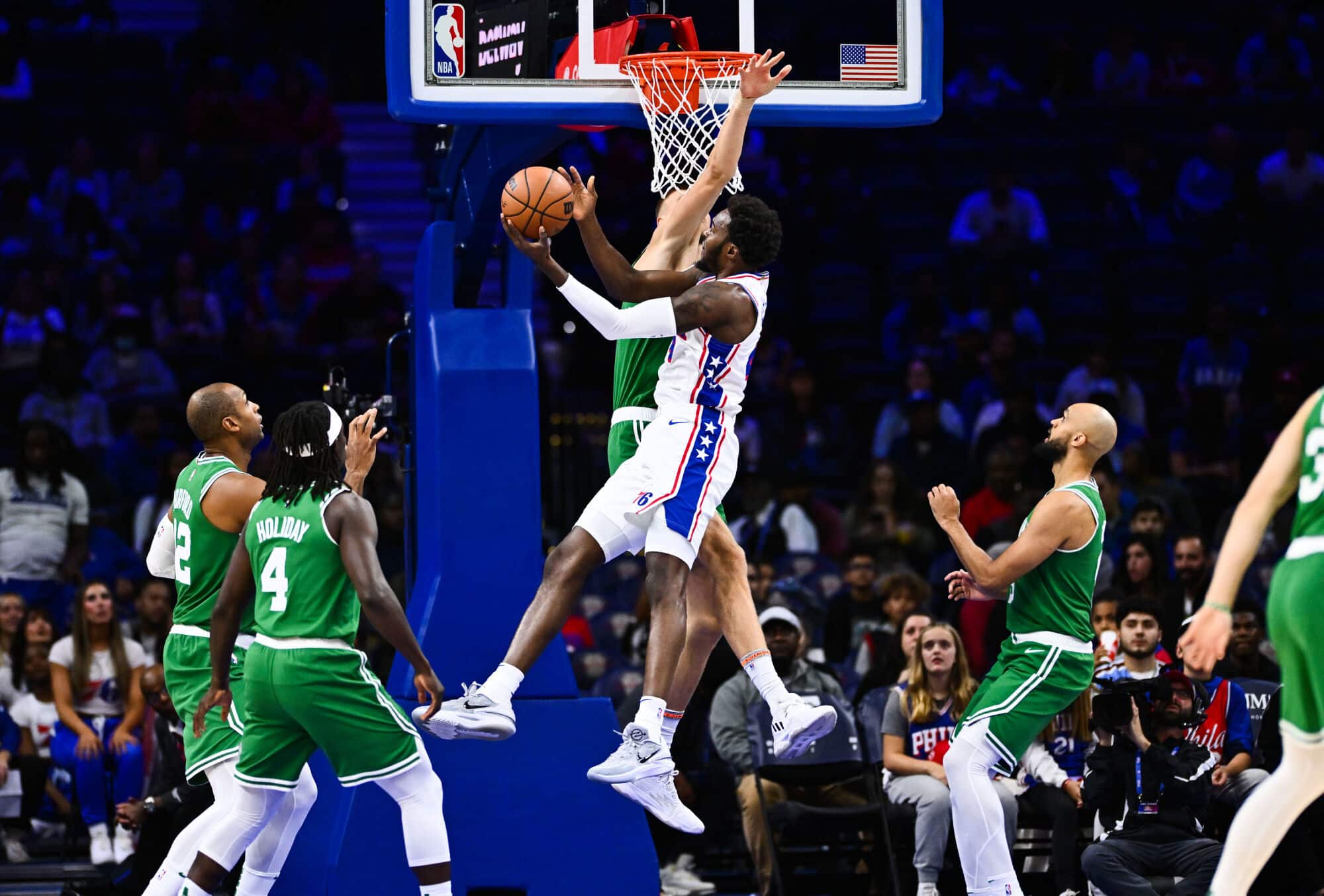Paul Reed (44) arremessa contra o pivô do Boston Celtics, Kristaps Porzingis (8), no primeiro quarto no Wells Fargo Center.